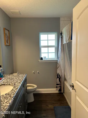 a bathroom with a granite countertop sink toilet and shower