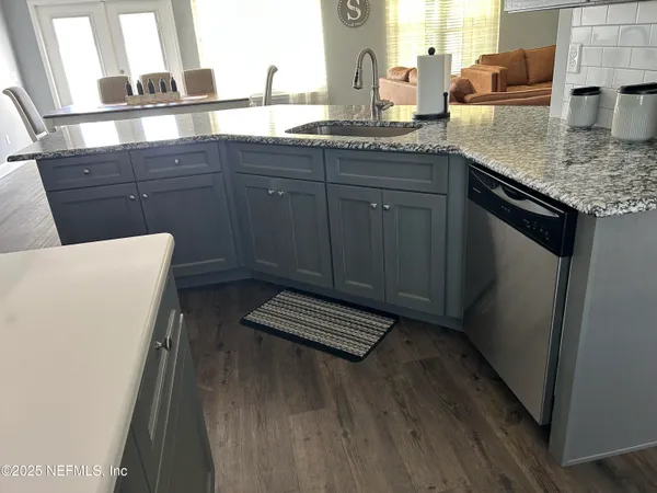a kitchen with granite countertop a sink stove and cabinets