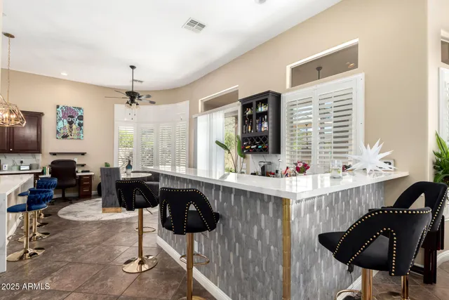 a kitchen with stainless steel appliances kitchen island granite countertop a dining table chairs and a white cabinets