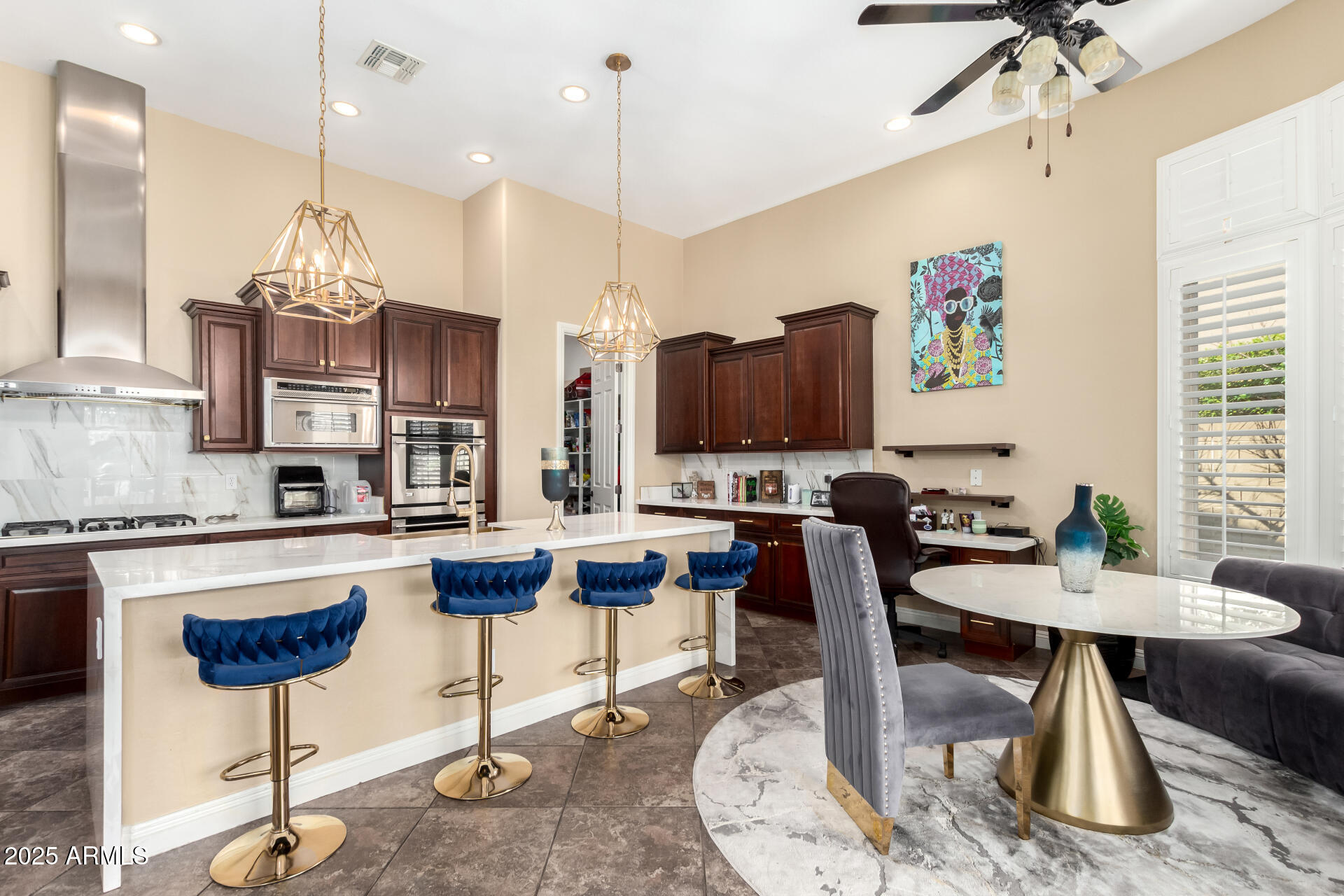 4935 West Yearling Road Phoenix, AZ 85083 - Photo 13 of 48 a kitchen with stainless steel appliances kitchen island granite countertop a dining table chairs and a white cabinets