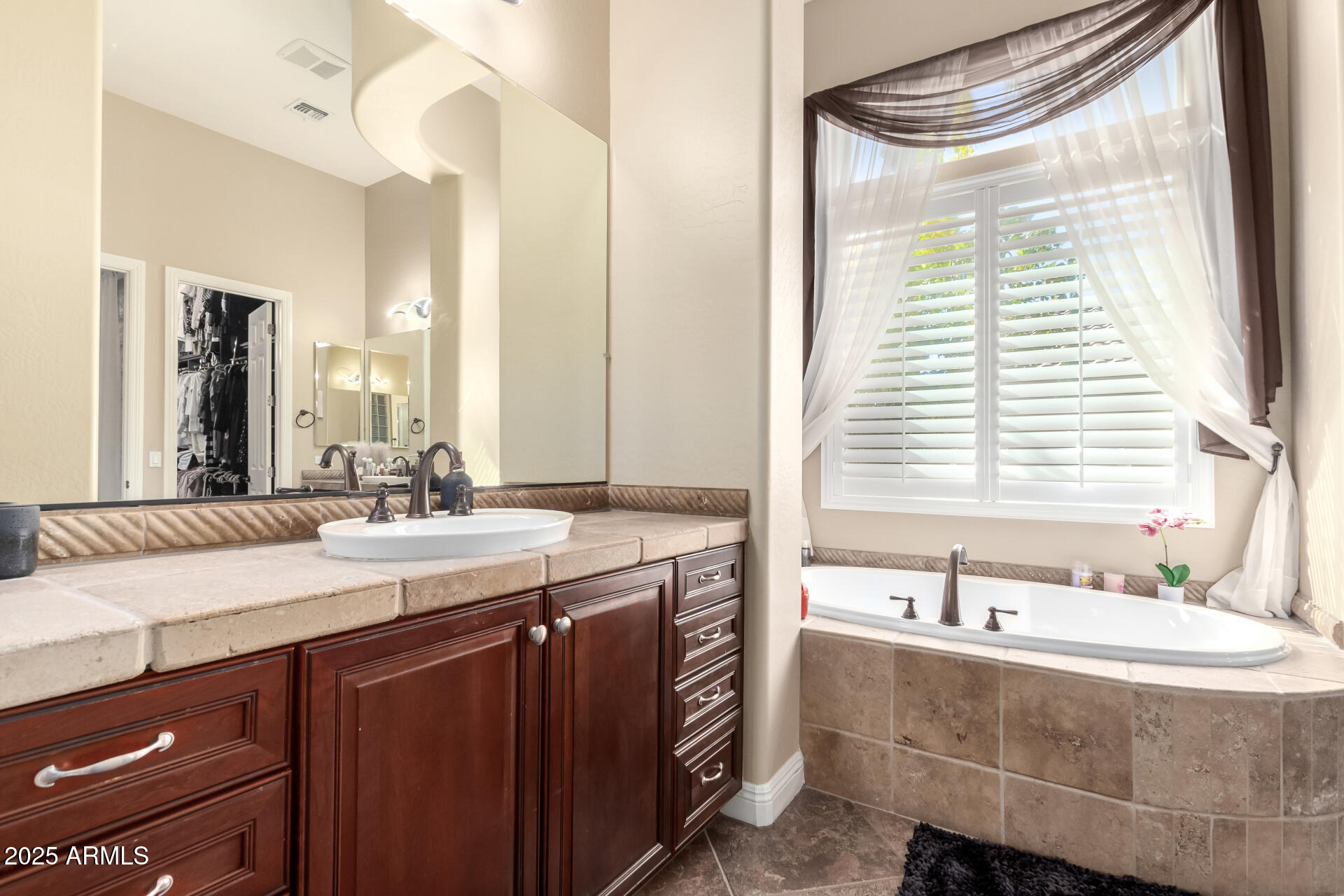 4935 West Yearling Road Phoenix, AZ 85083 - Photo 21 of 48 a bathroom with a double vanity sink bathtub and next to a window