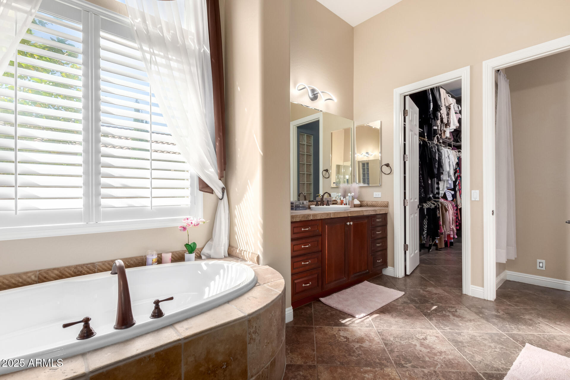 4935 West Yearling Road Phoenix, AZ 85083 - Photo 22 of 48 a bathroom with a tub a double vanity sink and a large mirror