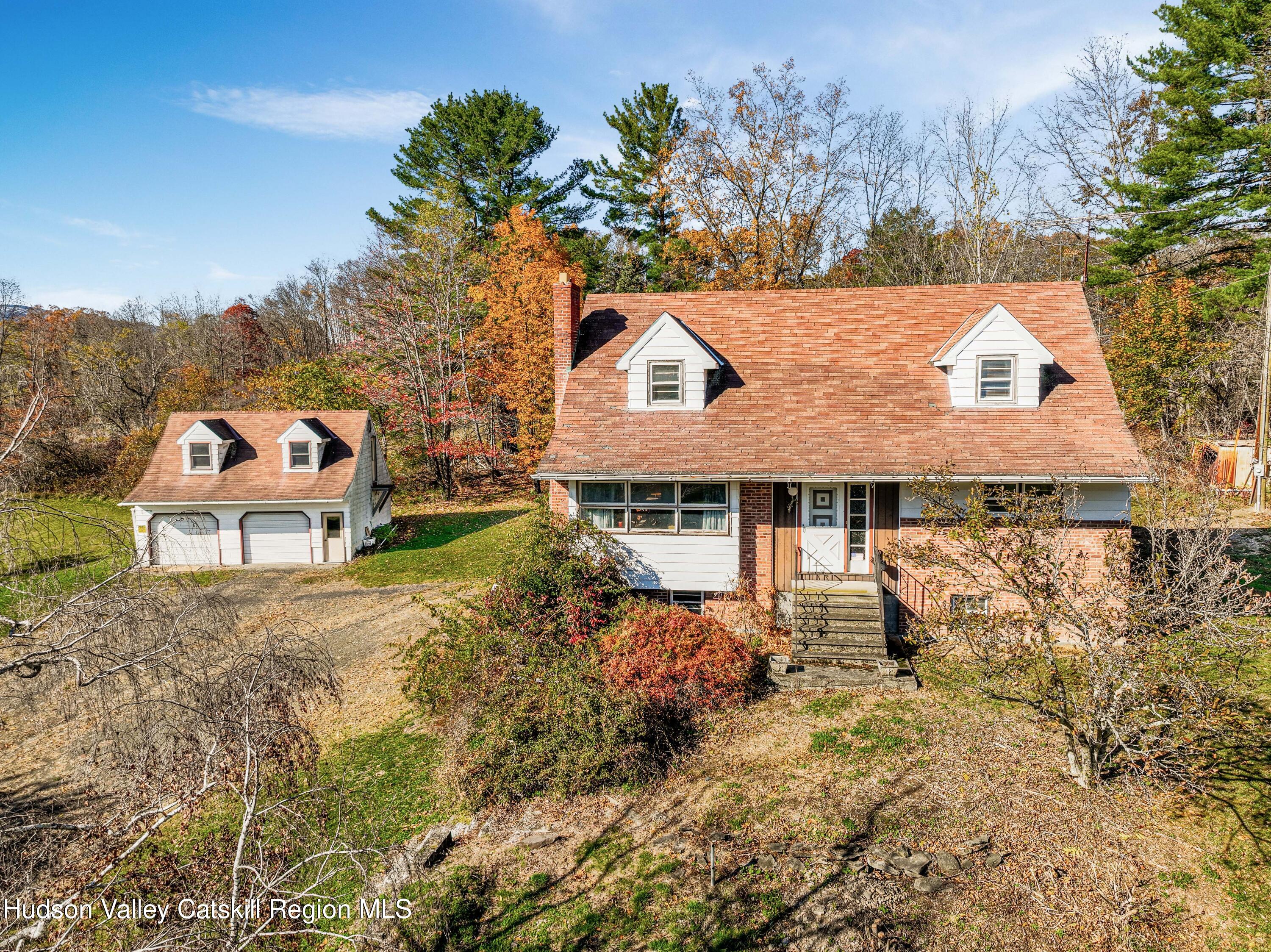 an aerial view of a house with a yard and mountain view in back