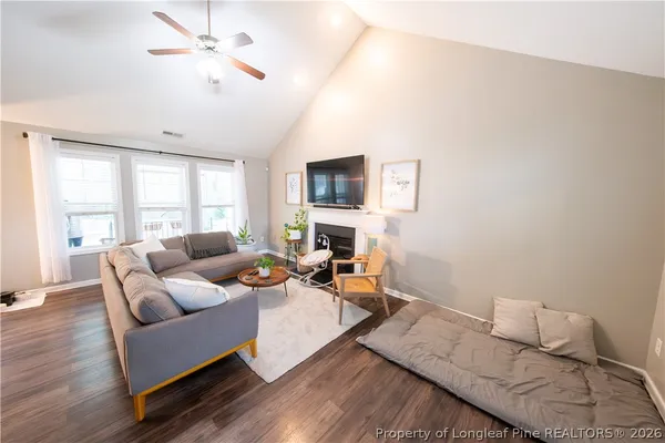 a living room with furniture a fireplace and a large window