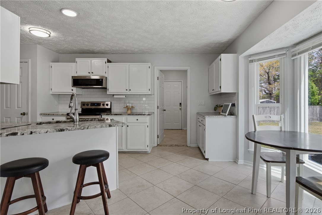 1837 Nuthatch Road Fayetteville, NC 28304 - Photo 15 of 43 a kitchen with a stove a sink and a refrigerator