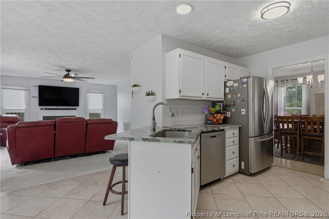 1837 Nuthatch Road Fayetteville, NC 28304 - Photo 19 of 43 a kitchen with stainless steel appliances a stove a sink cabinets and a refrigerator