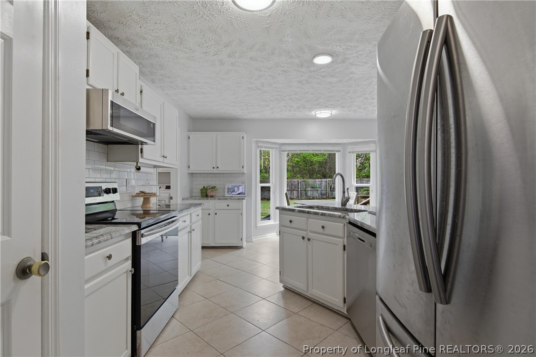 1837 Nuthatch Road Fayetteville, NC 28304 - Photo 22 of 43 a kitchen with stainless steel appliances granite countertop a refrigerator sink and stove