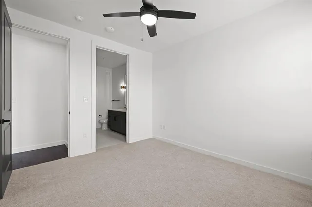 an empty room with closet and a chandelier fan