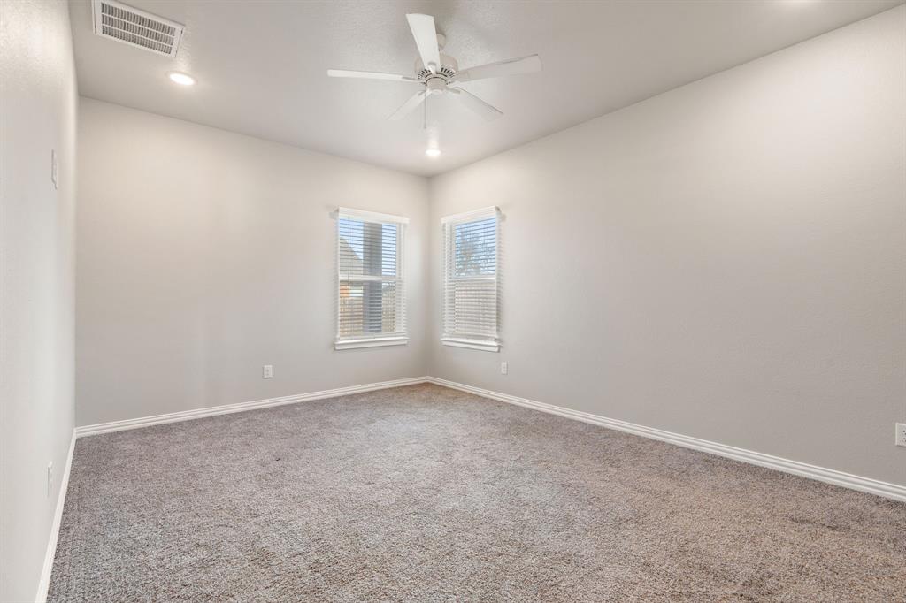 2306 Church Street Greenville, TX 75401 - Photo 12 of 24 en empty room with windows and ceiling fan