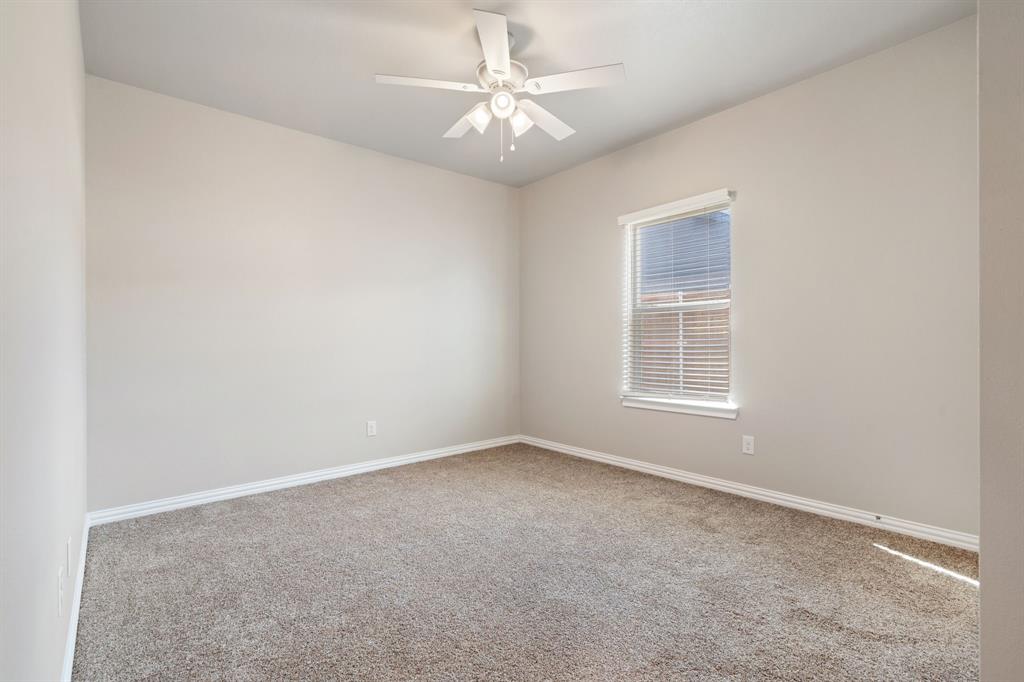 2306 Church Street Greenville, TX 75401 - Photo 19 of 24 an empty room with windows and chandelier fan
