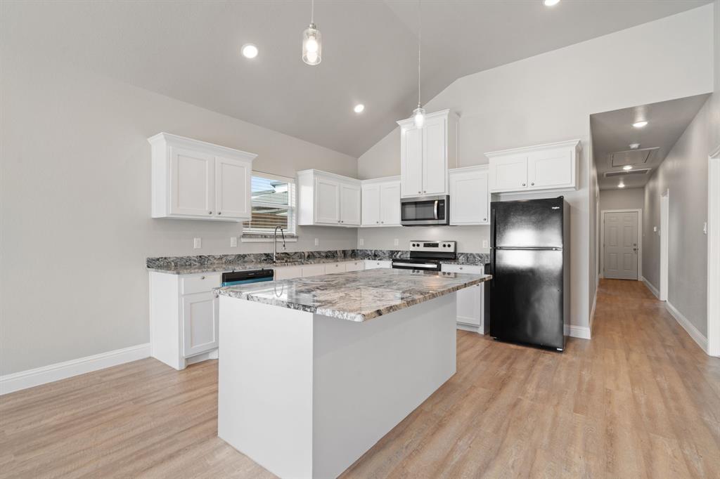 2306 Church Street Greenville, TX 75401 - Photo 10 of 24 a kitchen with stainless steel appliances granite countertop a refrigerator and a stove top oven