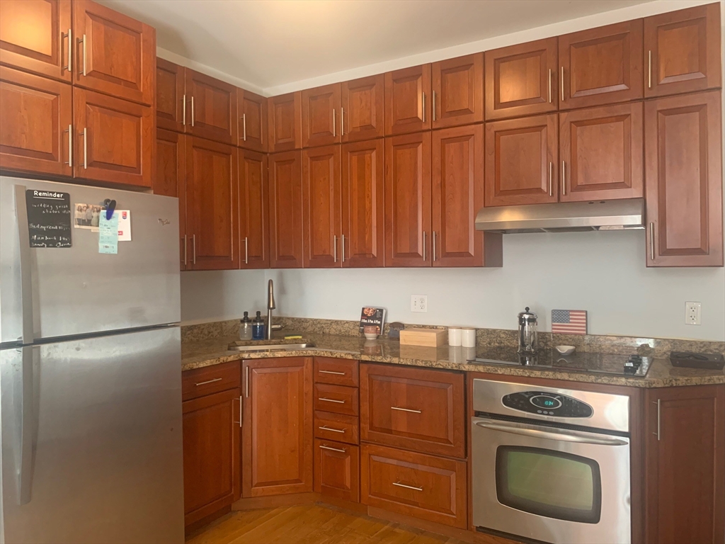 483 Beacon Street, Unit 26 Boston, MA 02115 - Photo 3 of 9 a kitchen with stainless steel appliances granite countertop a refrigerator sink and cabinets