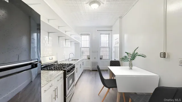 a kitchen with granite countertop white cabinets and white appliances