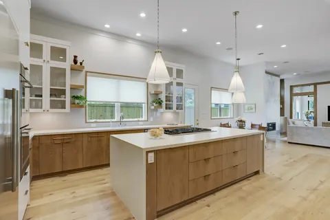 a kitchen with stainless steel appliances granite countertop a sink a stove and a large window