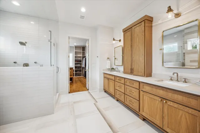 a spacious en suite bathroom with a double vanity sink and a mirror