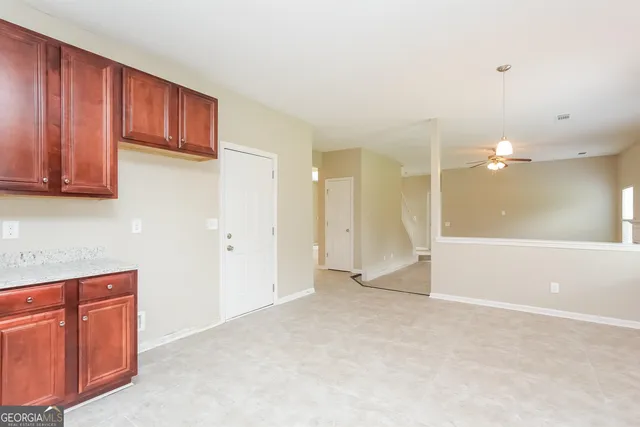 a view of an empty room with wooden floor and cabinet