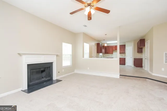 a view of an empty room with a fireplace and a window