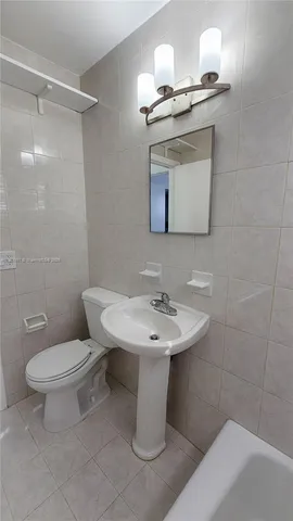 a bathroom with a sink toilet and mirror