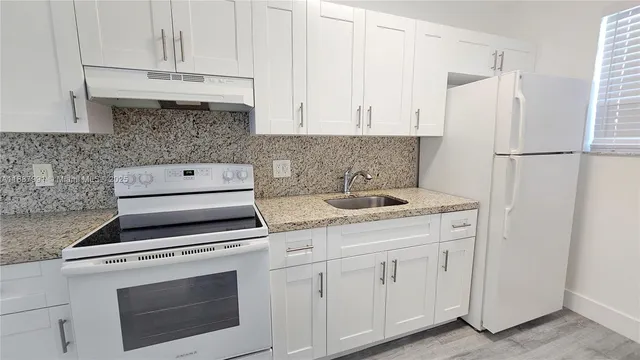 a kitchen with white cabinets and white appliances