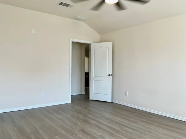 a view of an empty room with wooden floor