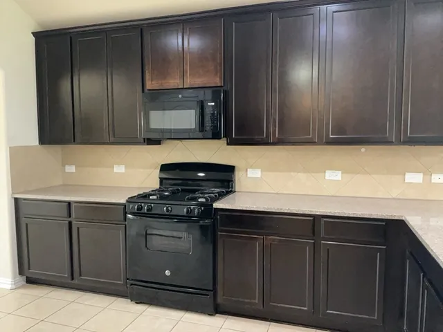 a kitchen with granite countertop wooden cabinets and stainless steel appliances