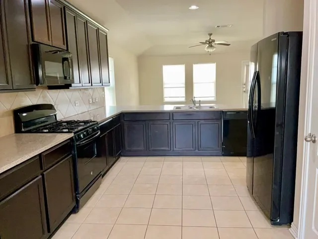 a kitchen with stainless steel appliances granite countertop a refrigerator and a sink