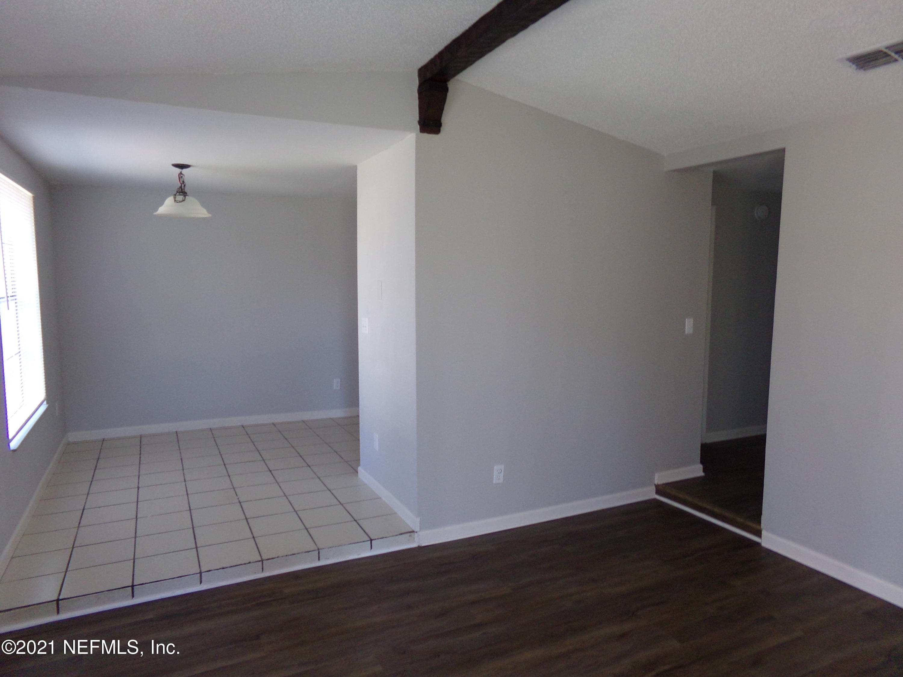 2652 Sunrise Village Drive, Unit C Orange Park, FL 32065 - Photo 3 of 7 a view of an empty room with wooden floor and a window