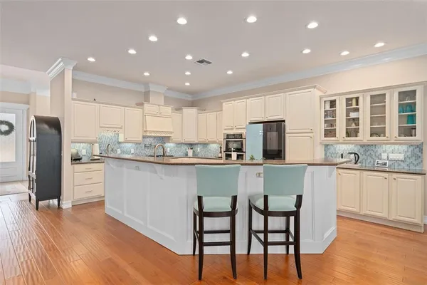 a kitchen with stainless steel appliances granite countertop a refrigerator and a stove top oven