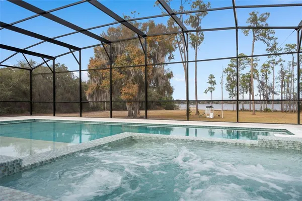 a view of a house with swimming pool and a yard with trees