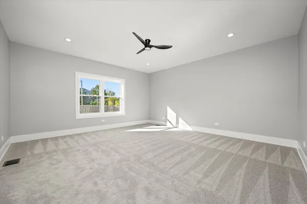 an empty room with windows and fan