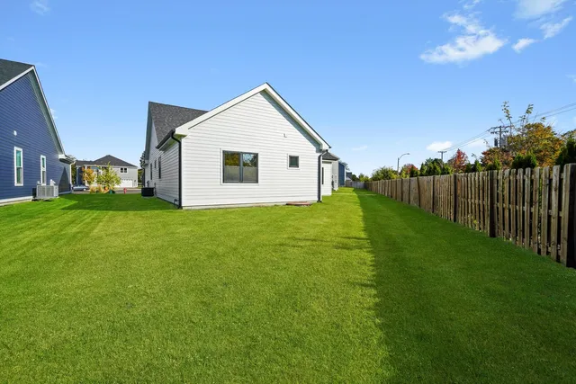 a view of a yard with wooden fence