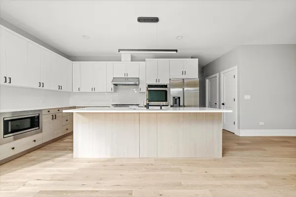 a kitchen with stainless steel appliances granite countertop a stove a sink and a refrigerator