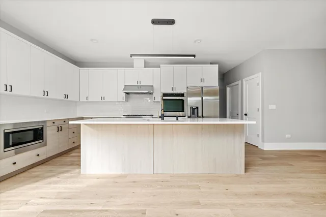 a kitchen with stainless steel appliances granite countertop a stove a sink and a refrigerator