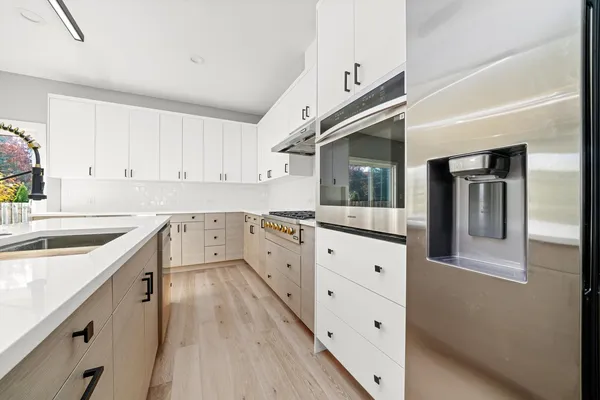 a kitchen with granite countertop white cabinets and white appliances