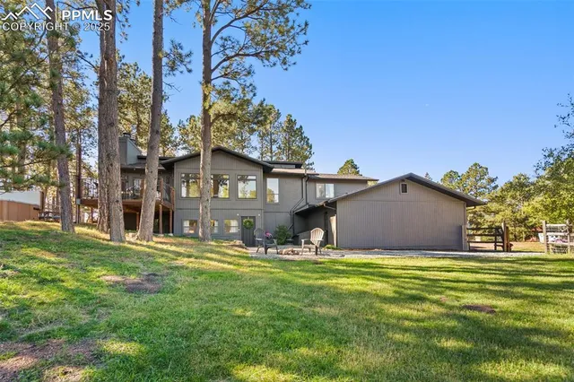 a view of a house with a big yard and large tree