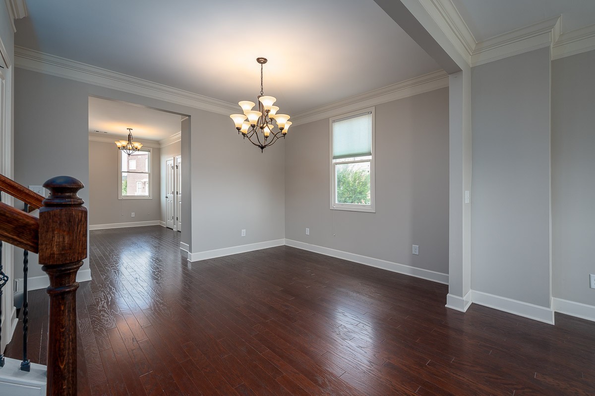 2069 Rural Plains Circle Franklin, TN 37064 - Photo 12 of 34 an empty room with wooden floor chandelier and windows