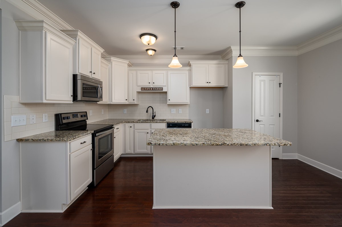 2069 Rural Plains Circle Franklin, TN 37064 - Photo 14 of 34 a kitchen with stainless steel appliances granite countertop a sink a stove a refrigerator and white cabinets with wooden floor