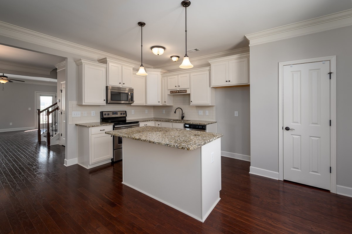 2069 Rural Plains Circle Franklin, TN 37064 - Photo 15 of 34 a kitchen with stainless steel appliances kitchen island granite countertop a stove a sink and a wooden floor