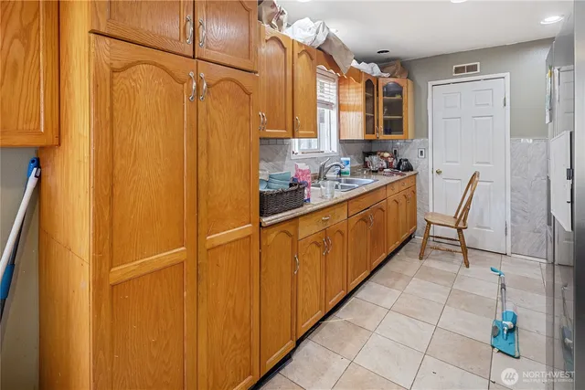 a kitchen with stainless steel appliances a refrigerator and a view of living room