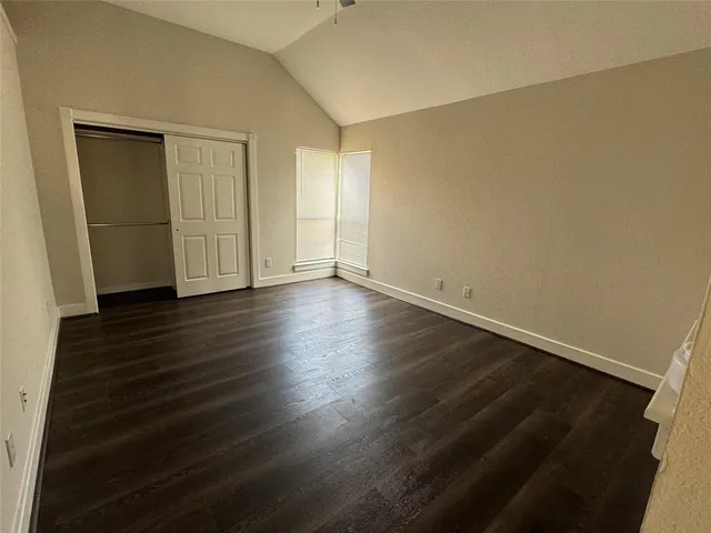 an empty room with wooden floor and closet
