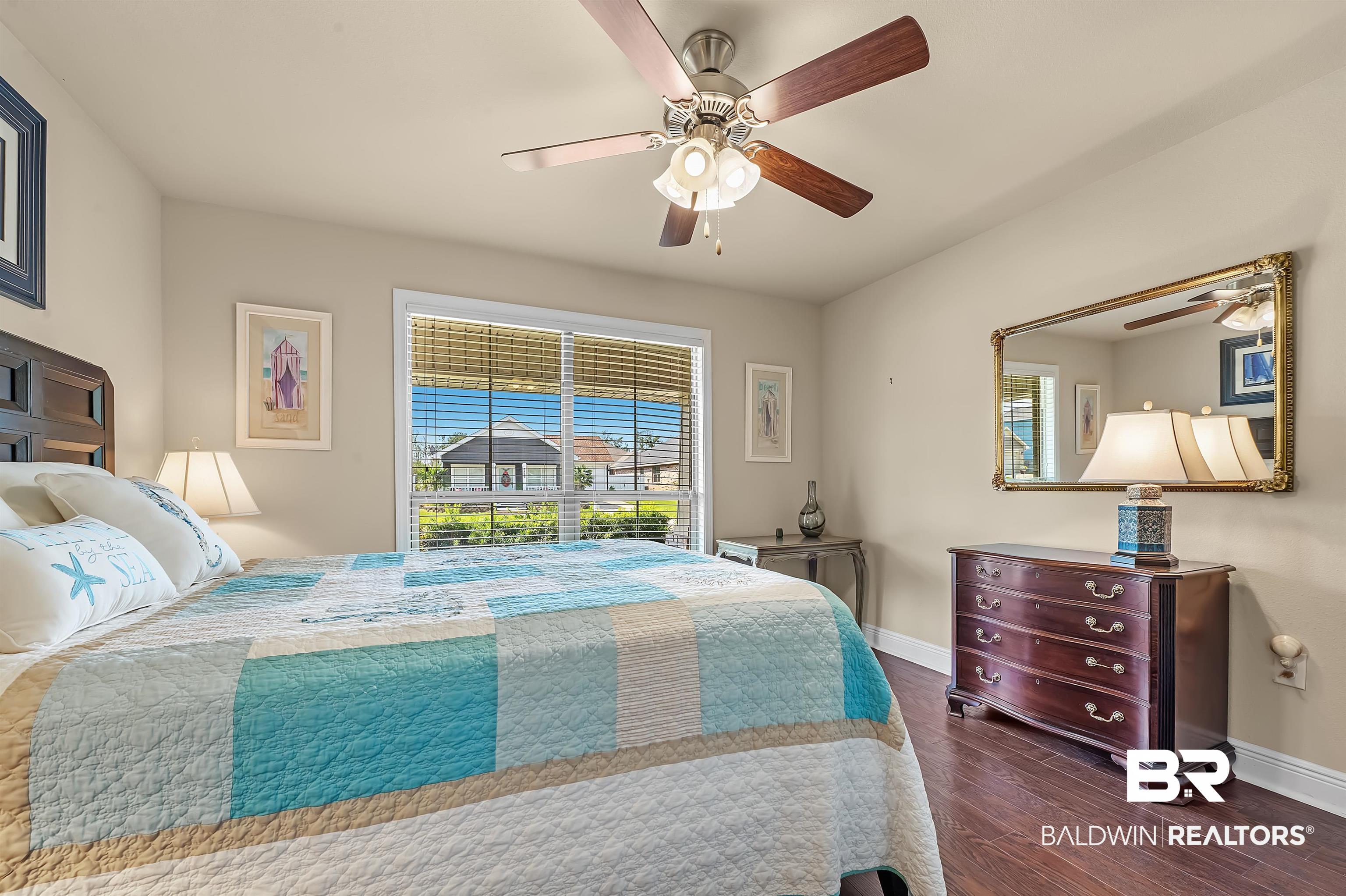 8896 Allay Lane Foley, AL 36535 - Photo 50 of 57 Bedroom featuring ceiling fan, multiple windows, and dark hardwood / wood-style flooring