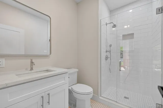 a bathroom with a toilet sink a shower and a mirror