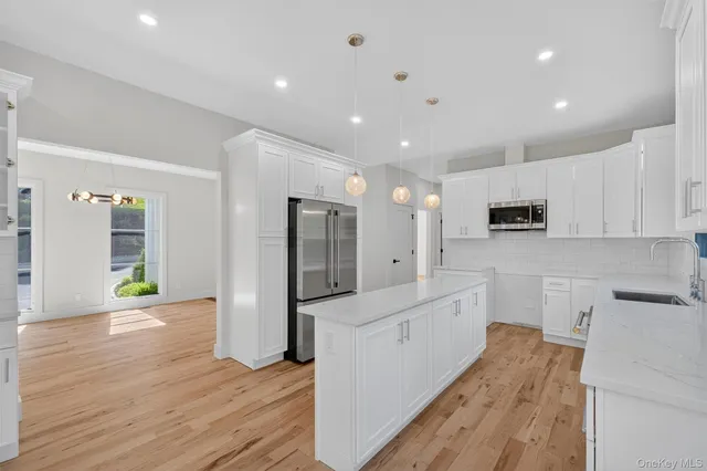 a large kitchen with stainless steel appliances a refrigerator and a stove top oven