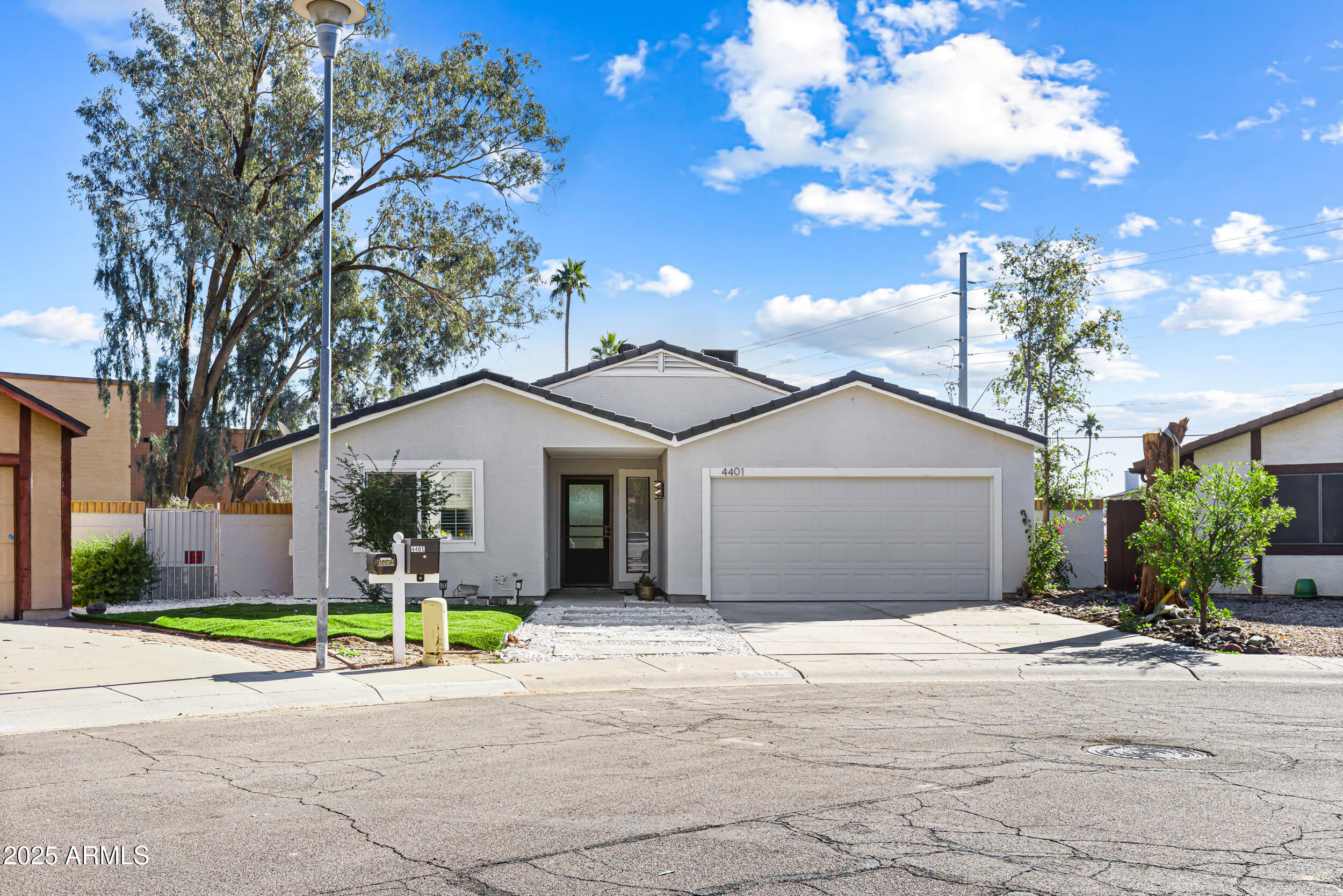 a front view of a house with a yard and potted plants