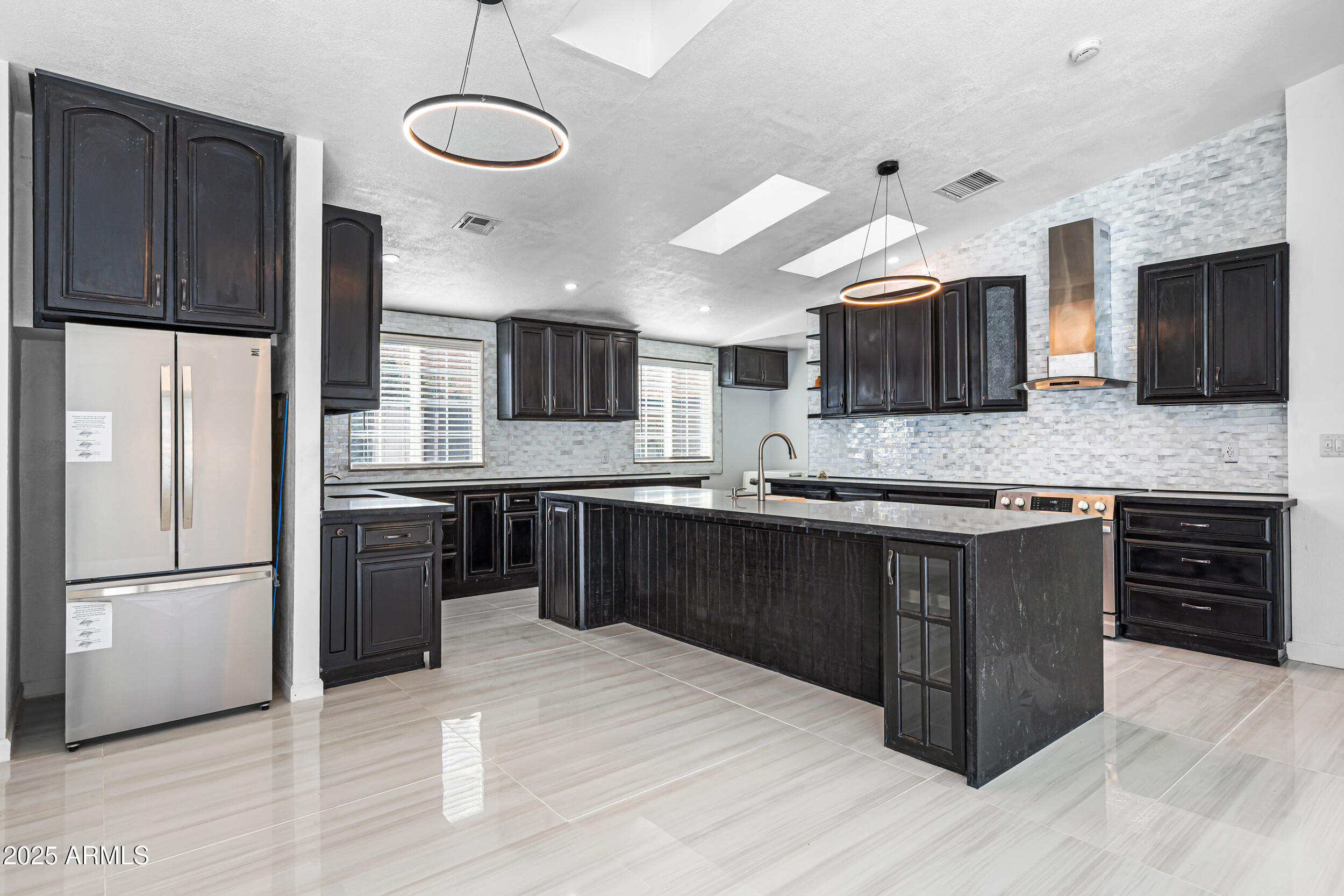 4401 West McRae Way Glendale, AZ 85308 - Photo 12 of 30 a kitchen with stainless steel appliances kitchen island granite countertop a refrigerator stove and sink