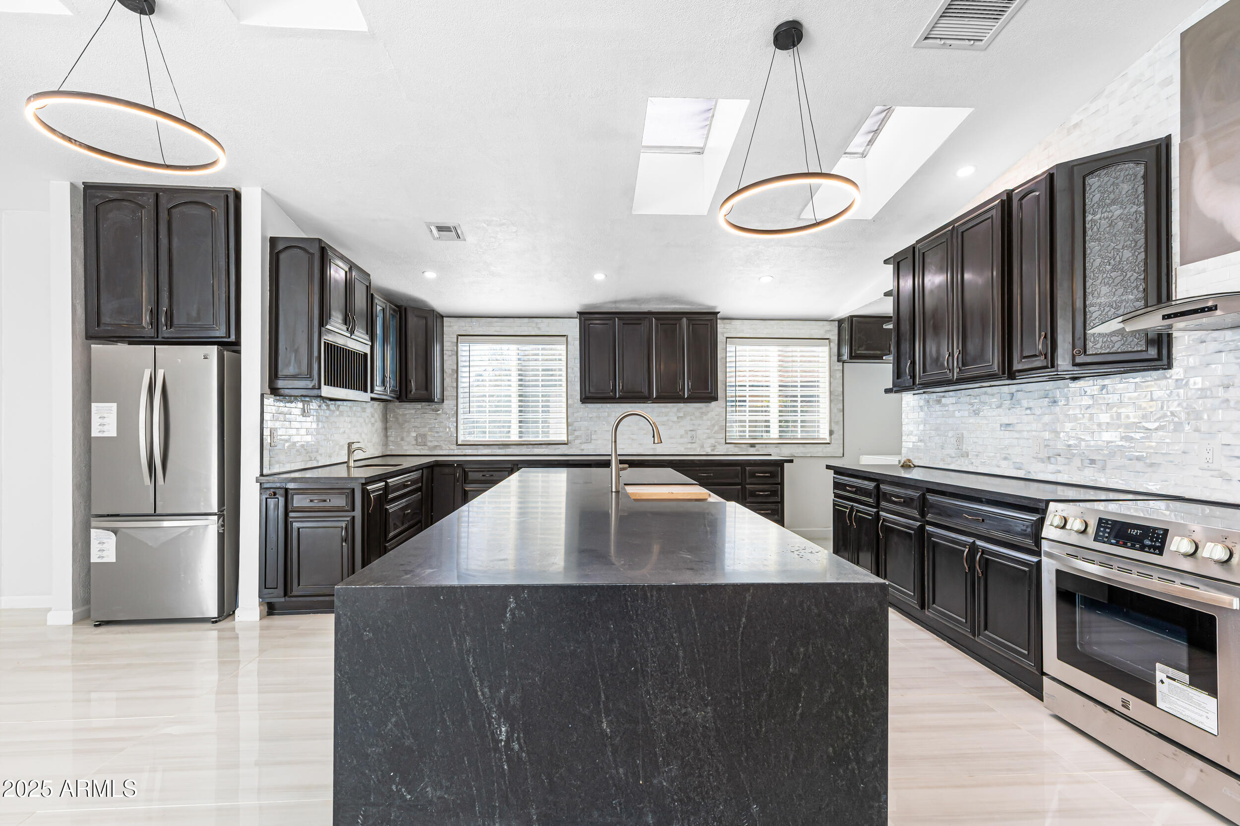 4401 West McRae Way Glendale, AZ 85308 - Photo 13 of 30 a kitchen with stainless steel appliances granite countertop a stove a sink dishwasher a refrigerator and a microwave oven with cabinets