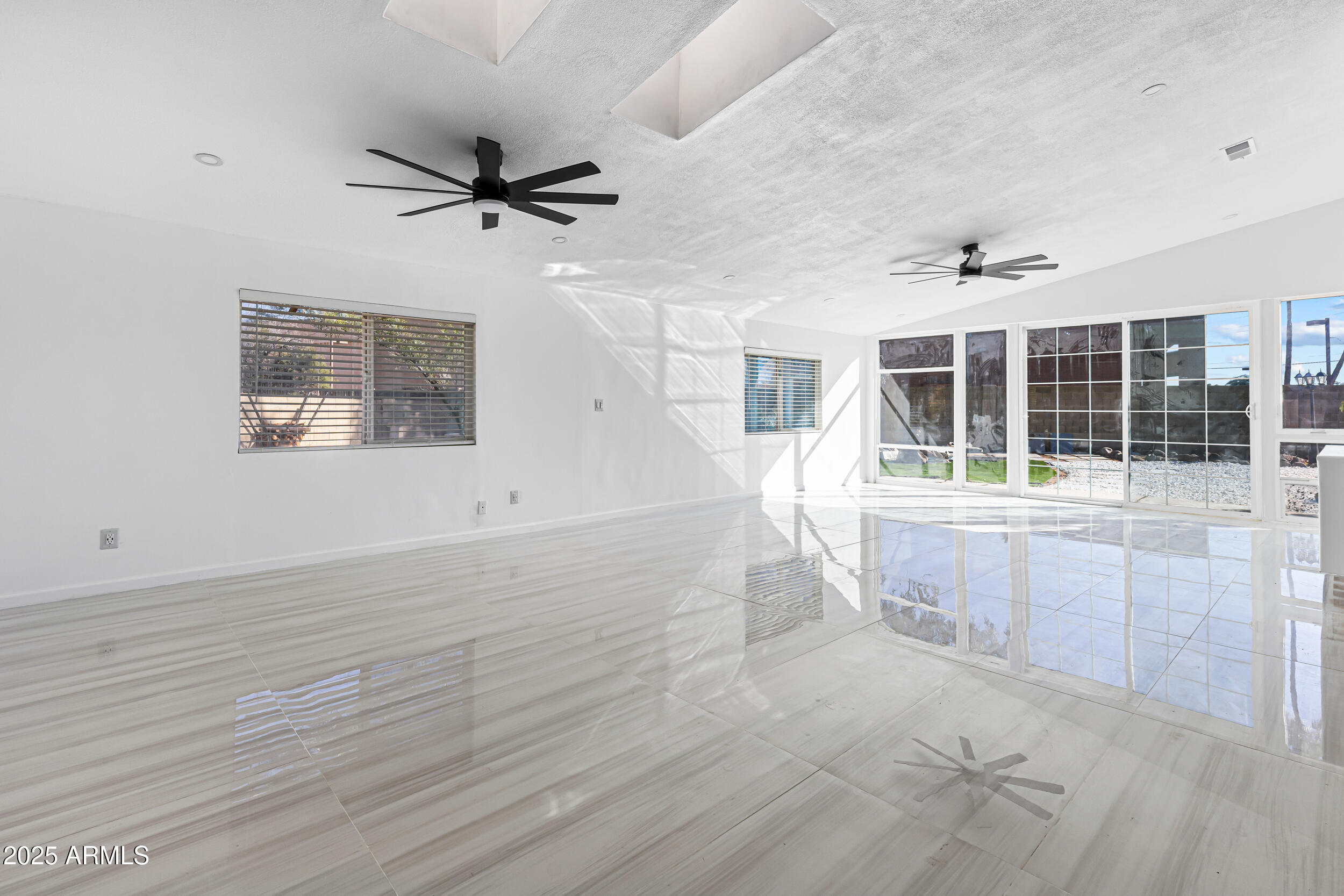 4401 West McRae Way Glendale, AZ 85308 - Photo 4 of 30 an empty room with wooden floor and windows