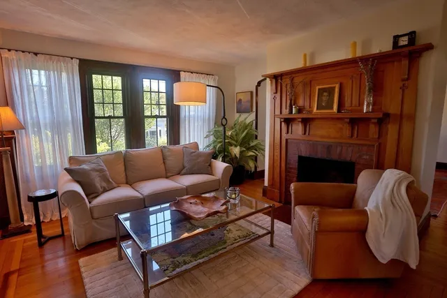 a living room with furniture fireplace and a window