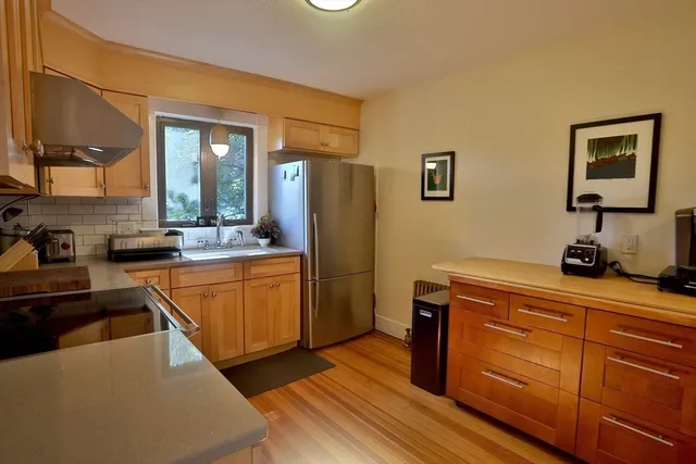 a kitchen with stainless steel appliances granite countertop a refrigerator and a stove top oven