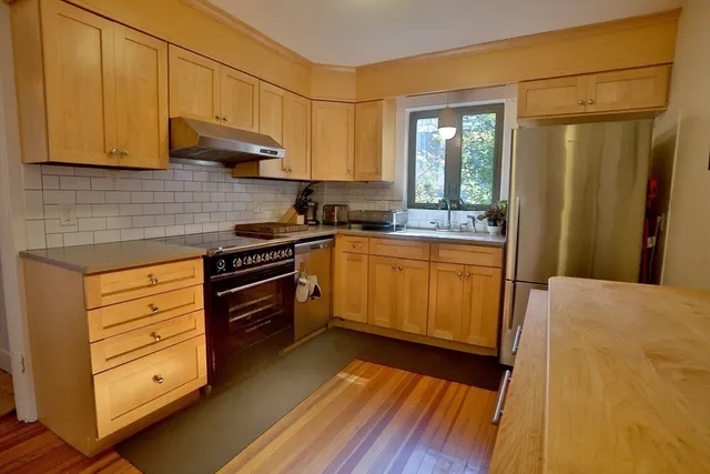 a kitchen with stainless steel appliances granite countertop a sink a stove and cabinets